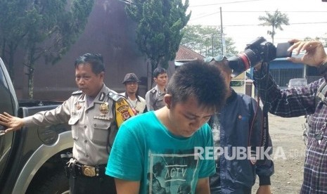 Tersangka pembobolan rekening ATM nasabah, Rian Adidaya (22 tahun) tertunduk malu ketika digiring ke Mapolsek Manonjaya, Kabupaten Tasikmalaya, Jawa Barat, Kamis (19/10). 