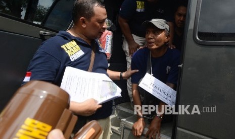 Tersangka Perampokan yang menewaskan enam orang di Pulo Mas Ius Pane (kanan) menjalani Pra Rekonstruksi di Tempat Kejadian Perkara Pulo Mas, Jakarta Timur, Jumat (6/1).