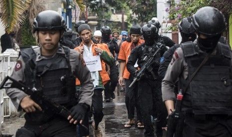 Tersangka teroris SH (kanan) dan AR (kiri) dikawal ketat petugas Densus 88 Antiteror saat rekonstruksi rencana pembuatan bom di Kiaracondong, Bandung, Jawa Barat, Kamis (26/10)