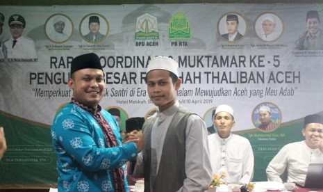 Tgk Marbawi Yusuf (berpeci hitam) bersalaman dengan Tgk Ismail Ismail M Husen seusai pemilihan Rais 'Am (ketua umum) Rabithah Thaliban Aceh (RTA) priode 2019-2022.