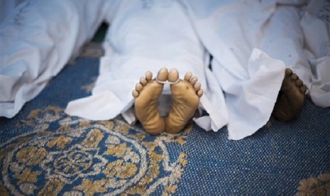 The corpse of a supporter for Egypt's ousted President Mohammed Morsi, killed during clashes with security forces at Nasr City, where pro-Morsi protesters have held a weeks-long sit-in, lies down on the floor of a field hospital in Cairo, Egypt, Saturday, 