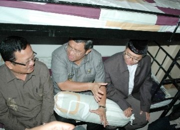 The Governor of West Java, Ahmad Heriyawan (center) sits on the bed in Yatim Apartment, recently.  