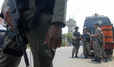 The police take guard while the bomb squad examine the bombing scene in Depok, outskirt of Jakarta, Sunday. 