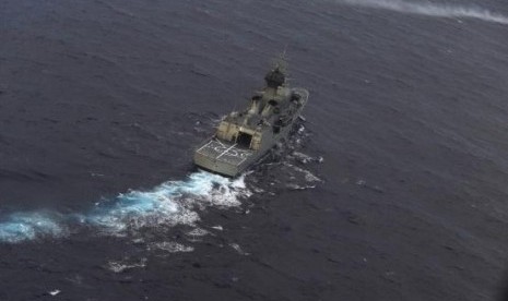 The Royal Australian Navy ship HMAS Perth is guided into position by a Royal New Zealand Airforce (RNZAF) P-3K2 Orion aircraft to recover an object in the southern Indian Ocean, on April 13, 2014.