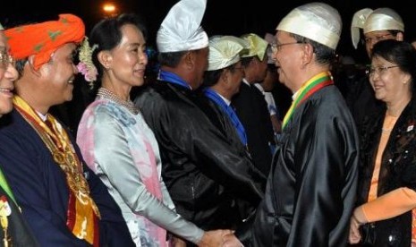 Thein Sein (kiri) menyalami Aung San Suu Kyi dalam sebuah acara kenegaraan.