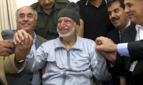 Then Palestinian President Yasser Arafat sits (center) surrounded by doctors from Tunis, Egypt and Jordan in his office in the West Bank City of Ramallah in this October 28, 2004 (file photo).   