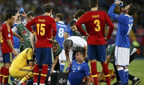 Thiago Motta (tengah), gelandang timnas Italia, menahan sakit akibat mengalami cedera saat menghadapi Spanyol di final Piala Eropa 2012. 