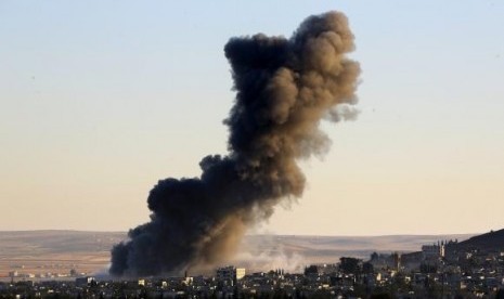 Thick black smoke rises over an eastern Kobani neighborhood following an air strike on November 8, 2014.