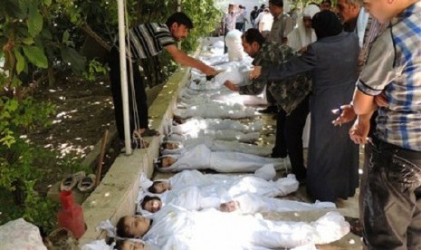 Syrian citizens try to identify dead bodies, after an alleged poisonous gas attack fired by regime forces, according to activists in Arbeen town, Damascus, Syria, Wednesday, Aug. 21, 2013. 