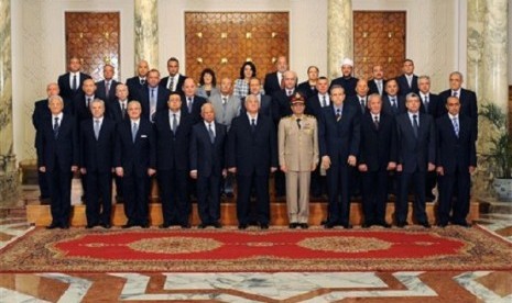 This image released by the Egyptian Presidency on Tuesday, July 16, 2013 shows interim President Adly Mansour, center, with his new cabinet ministers at the presidential palace in Cairo, Egypt. 