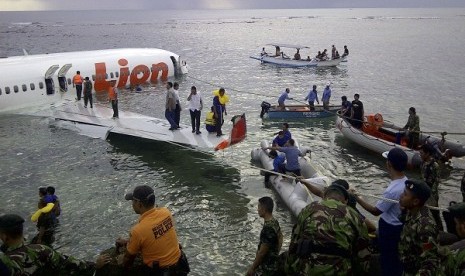 This photo released by Indonesia's National Rescue Team shows rescuers at the crash site of a Lion Air plane in Bali, Indonesia on Saturday, April 13, 2013.