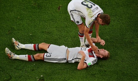 Thomas Mueller membantu Christoph Kramer yang sedang cedera dan berbaring saat laga final Piala Dunia 2014