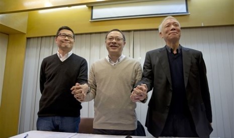 Three protest leaders, from left, Chan Kin-man, Benny Tai Yiu-ting and Chu Yiu-ming, pose for photographers during a news conference in Hong Kong Tuesday, Dec. 2, 2014 as they announce that they will surrender to police.