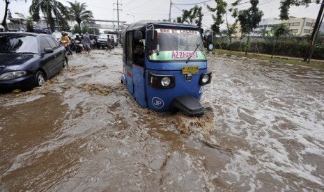 Three wheelers tries to pass through an inundated area in Jakarta. (illustration)  