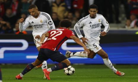 Tiago Santos (tengah) dari Lille beraksi melawan Kylian Mbappe (kiri) dan Jude Bellingham (kanan) dari Real Madrid selama pertandingan Liga Champions UEFA di Lille, Kamis, (3/10/2024). 