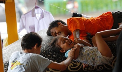 Tiga anak yang mengungsi akibat banjir di Pengadegan,Jakarta Selatan.