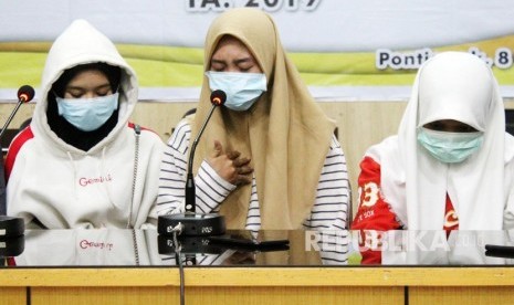 Tiga dari 12 siswi SMU yang diduga menjadi pelaku dan saksi dalam kasus penganiayaan siswi SMP berinisial AU (14) memberi keterangan saat jumpa pers di Mapolresta Pontianak, Kalimantan Barat, Rabu (10/4/2019). 