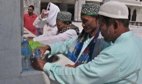 Tiga jamaah haji Indonesia asal Sidoharjo, Jatim, memasukan air zamzam ke dalam botol