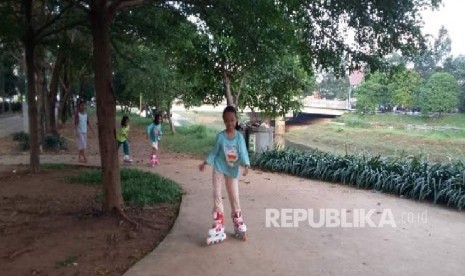 Tiga orang anak bermain sepatu roda di taman BKT Duren Sawit Jakarta, Selasa (25/4).