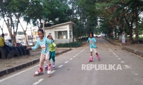 Tiga orang anak bermain sepatu roda di taman BKT Duren Sawit Jakarta, Selasa (25/4).