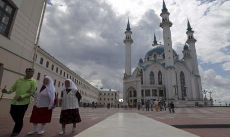 Tiga orang berjalan di sebuah lapangan dekat Masjid Kul Sharif di Kazan, ibukota Tatarstan Rusia. (Roman Kruchinin/Reuters)