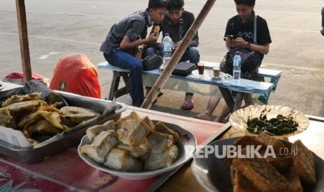 Tiga orang pemudik nampak melepas lelah di warung kopi di terminal bus Pulogadung Jakarta, Senin (11/7). (Republika/Darmawan)