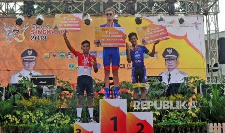 Tiga pebalap Jesse Ewart (tengah), Firdaus Ahmad Yoga Ilham (kanan) dan Jamalidin Novardianto, menerima penghargaan etape kedua Tour de Singkarak (TDS) 2019, di Kawasan Jam Gadang, Bukitinggi, Sumatera Barat, Ahad (3/11/2019). 