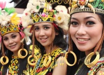 Tiga perempuan berpakian tradisional dayak ketika menari menyambut dan mengawal obor api SEA Games XXVI di halaman Balaikota Balikpapan, Kaltim, Rabu (2/11).