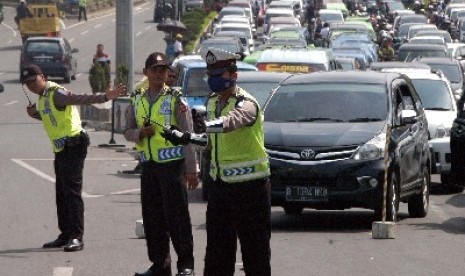 Tiga Polisi mengatur lalu lintas menuju kawasan wisata Puncak di Gadog, Ciawi, Bogor, Jabar.