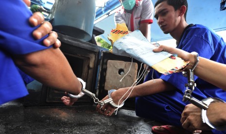 Tiga tersangka melakukan pemusnahan narkoba jenis shabu yang digelar oleh Badan Narkotika Nasional (BNN) di Kantor BNN Jakarta, Rabu (3/2). 