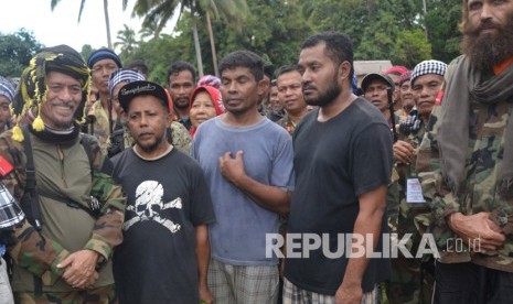 Tiga warga negara Indonesia dan Norwegia  berdiri di samping Pemimpin Front Pembebasan Nasional Moro (MNLF)  Nur Misuari  setelah para sandera dibebaskan dari kelompok militan Abu Sayyaf , di Jolo , Sulu di Filipina.