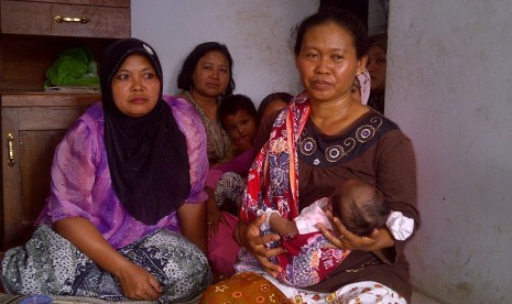 Tijah (menggendong cucunya) isteri Salim Kancil.