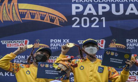 Tim balap motor NTB Aldia Aqsal (kiri) dan Nyoman Rajendra (kanan) memperlihatkan medalinya saat penyerahan medali pada Motor Cross kategori Standar Beregu PON Papua di Arena Balap Motor Tanah Miring, Kabupaten Merauke, Papua, Rabu (6/10/2021). Tim balap motor NTB meraih medali emas sementara medali perak diraih oleh tim balap motor Papua Barat dan medali perunggu diraih tim balap motor Papua-B.