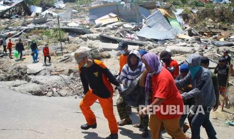 Tim Basarnas dibantu warga mengangkat jenazah saat evakuasi pascagempa di Kompleks Perumahan Nasional Kelurahan Bala Roa, Kota Palu, Sulawesi Tengah, Selasa (2/10). 