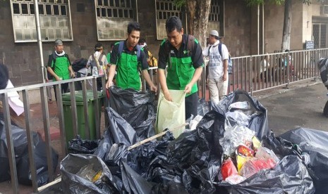  Tim BIS Dompet Dhuafa dan AQL Islamic Center, tengah membersihkan sampah di Pintu Al-Fattah Masjid Istiqlal, Jumat (4/11). 