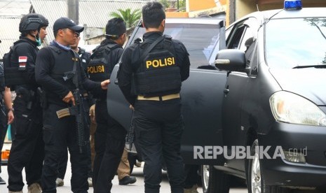 Tim Densus 88 mengamankan istri terduga Teroris saat dilakukan penggerebekan di Gempol, Tangerang, Banten, Rabu (16/5).