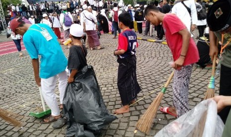 Tim Divisi Kebersihan membersihkan sampah di area Reuni Aksi 212.