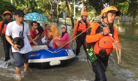 Tim DMC Dompet Dhuafa mengevakuasi warga terdampak banjir.