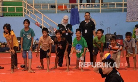  Tim Dukungan Psikososial Kemensos bermain dengan anak-anak pengungsi eks-Gafatar di Gedung Pusat Olahraga Persahabatan Korea Indonesia (POPKI), Cibubur, Jakarta Timur, Jumat (29/1).  (Republika/Yasin Habibi)