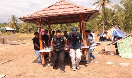 Tim Formula LAZ Al Azhar bergotong royong memindahkan saung yamg rusak akibat gempa.