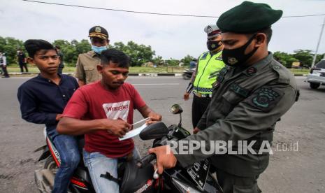 Tim gabungan Satuan Tugas (Satgas) penanganan COVID-19 memberikan masker saat operasi protokol kesehatan (Prokes), ilustrasi