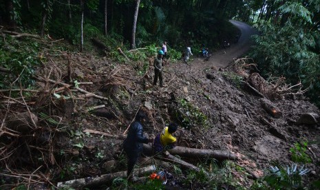 Tim gabungan tanggap bencana membersihkan material tanah longsor yang menutupi badan jalan utama Culamega, Kabupaten Tasikmalaya, Jawa Barat, Kamis (8/11/2018). 