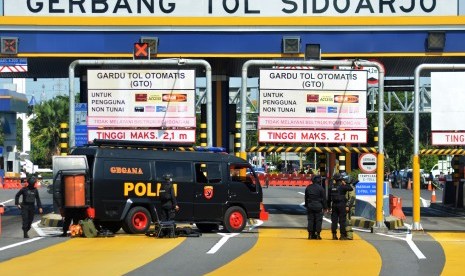 Tim Gegana Sat Brimob Polda Jawa Timur bersiap menjinakkan sebuah benda yang diduga bom di loket Pintu masuk Tol Sidoarjo, Jawa Timur, Jumat (18/5). Benda diduga bom berupa pipa yang dirangkai menjadi satu dengan kabel tersebut berhasil diledakkan oleh tim Gegana Sat Brimob Polda Jawa Timur.