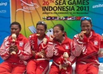 Tim Kano Putri Indonesia, Masrifah, Rasima, Sarce Aronggear dan Kanti Satyawati menggigit medali emas perolehan cabang Kano 200 meter K4 putri SEA Games XXVI di arena dayung Situ Cipule, Karawang, Jabar, Minggu (13/11).