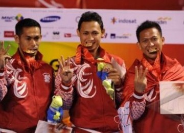 Tim karateka Indonesia (dari kiri) Aswar, Faizal Zainuddin, dan Fidelys Lolobua menunjukkan medali emas nomor kata beregu putra SEA Games XXVI Indonesia di Tennis Indoor Senayan, Jakarta, Sabtu (12/11).