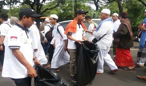 Tim kebersihan Lazismu melakukan bersih-bersih dalam aksi damai 212 di Monas, Jakarta, Jumat (2/12).