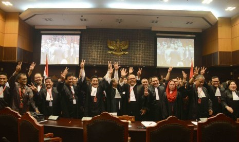 Tim kuasa hukum pasangan presiden nomer urut dua Jokowi-JK dan komisioner KPU berfoto bersama usai putusan sidang sengketa Pilpres di Gedung Mahkamah Konstitusi (MK), Jakarta, Kamis (21/8). Hasil dari sidang putusan tersebut Mahkamah Konstitusi menolak sel