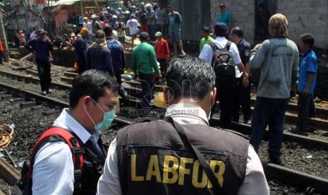  Tim Labfor melakukan olah tempat kejadian perkara (TKP) kecelakaan kereta api listrik dengan truk tangki di perlintasan kereta di Bintaro Permai, Jakarta Selatan, Selasa (10/12).  (Republika/Yasin Habibi)