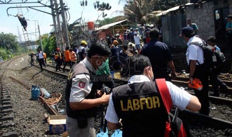  Tim Labfor melakukan olah tempat kejadian perkara (TKP) kecelakaan kereta api listrik dengan truk tangki di perlintasan kereta di Bintaro Permai, Tangerang Selatan, Selasa (10/12).  (Republika/Yasin Habibi)