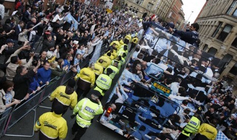 Tim Manchester City menggelar pawai tropi kemenangan di Manchester City. Tampak citizen--julukan suporter City--memenuhi sudut jalan dengan atribut kebanggan klub berwaran biru